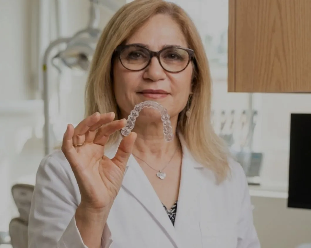 Dr. Emami holding a clear Invisalign aligner